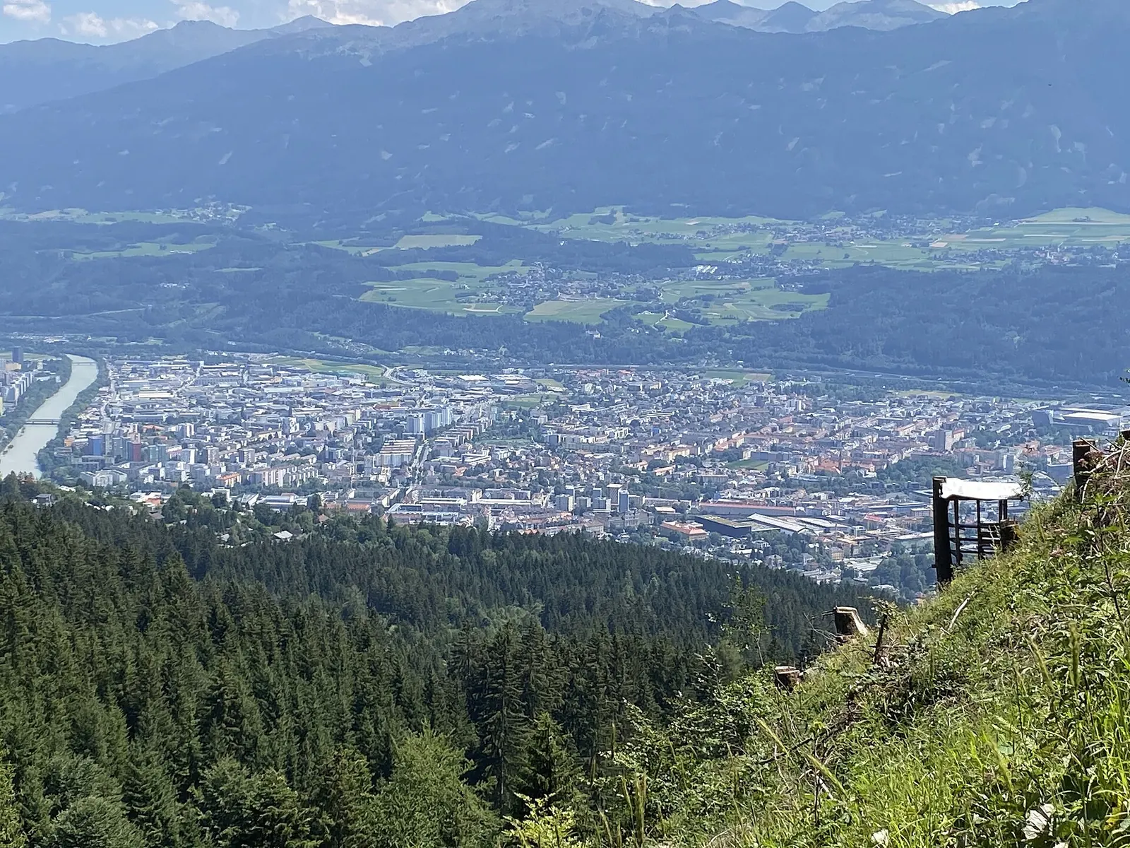 Paar spaziert am Innufer in Innsbruck vor den bunten Häusern von Mariahilf, dahinter die Nordkette