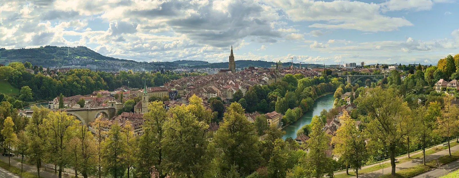 Paar steht im Rosengarten in Bern und blickt über die Dächer der Altstadt und den Bogen der Aare
