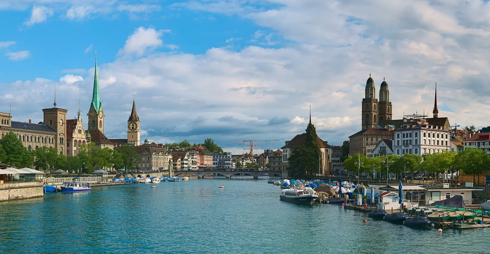 Zwei Menschen spazieren am Abend am Zürichsee entlang, im Hintergrund die Türme der Altstadt