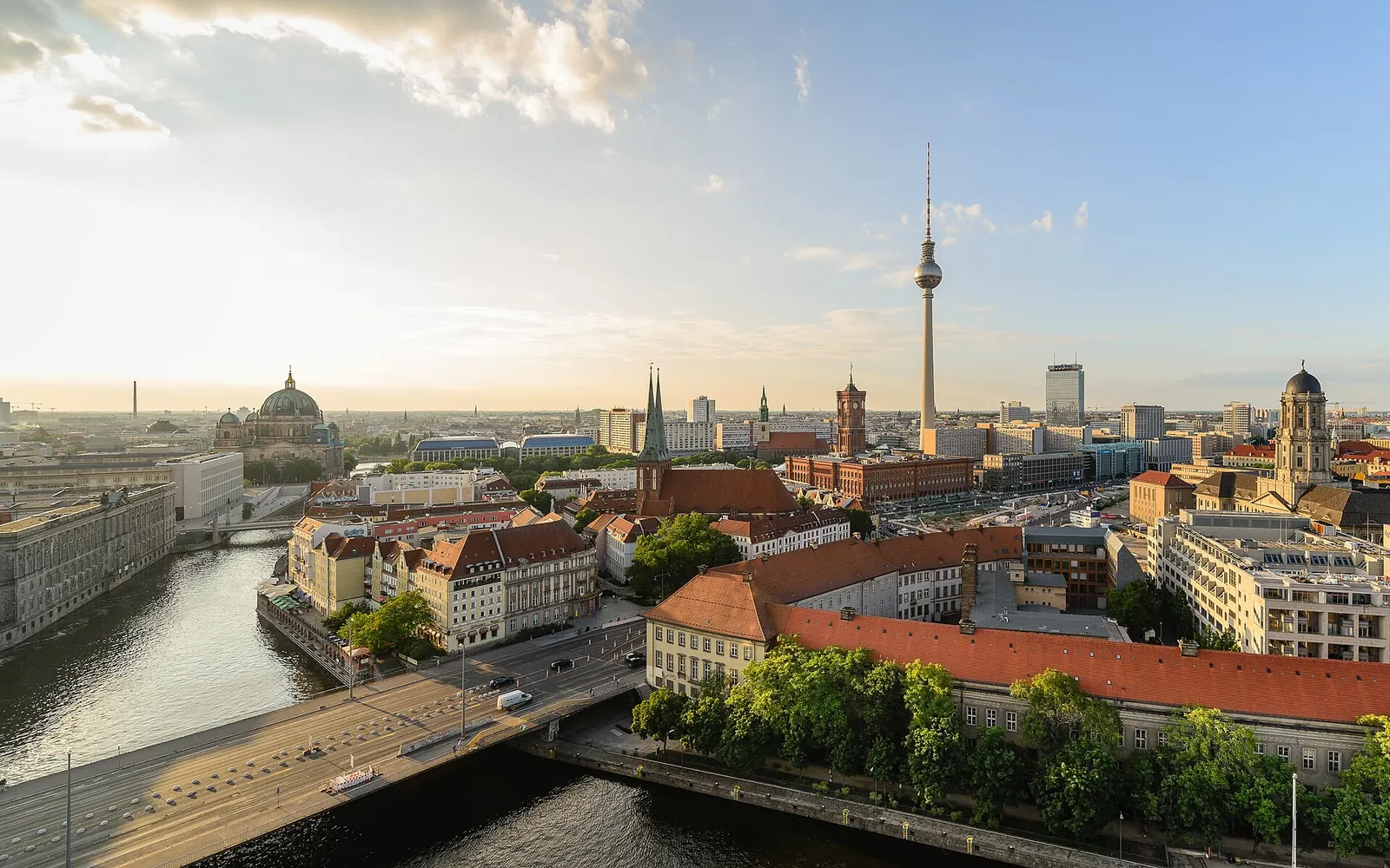 Zwei Menschen sitzen am Ufer des Landwehrkanals in Berlin-Kreuzberg in der Abendsonne