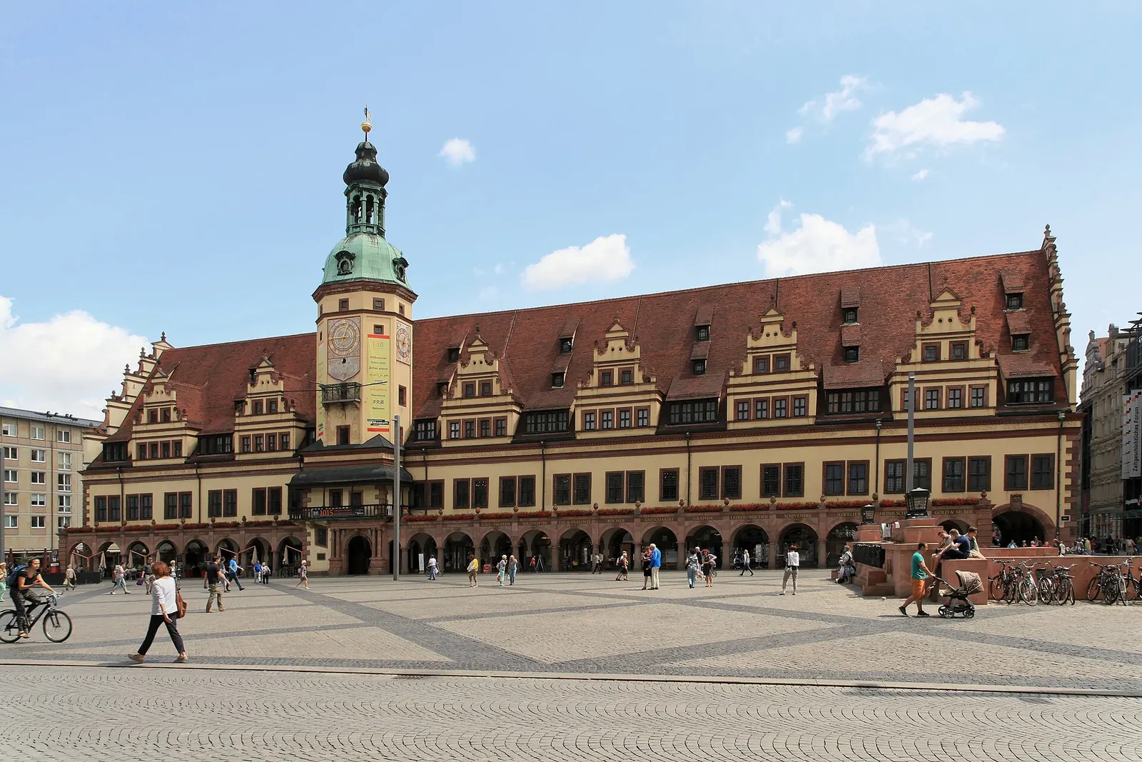 Paar sitzt am Ufer des Karl-Heine-Kanals in Leipzig-Plagwitz vor alten Backsteinfabriken