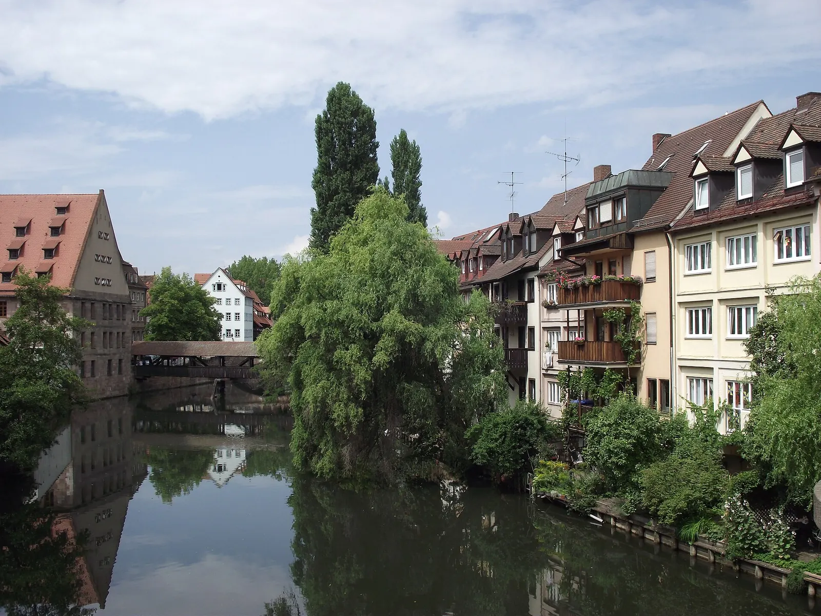 Paar steht auf einer Brücke über die Pegnitz in der Nürnberger Altstadt, im Hintergrund Fachwerkhäuser