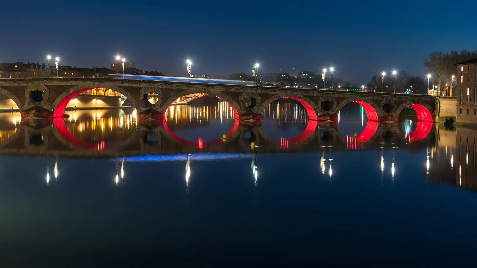 Couple assis sur les marches du quai de la Daurade, la Garonne et le pont Neuf dorés par le soleil couchant