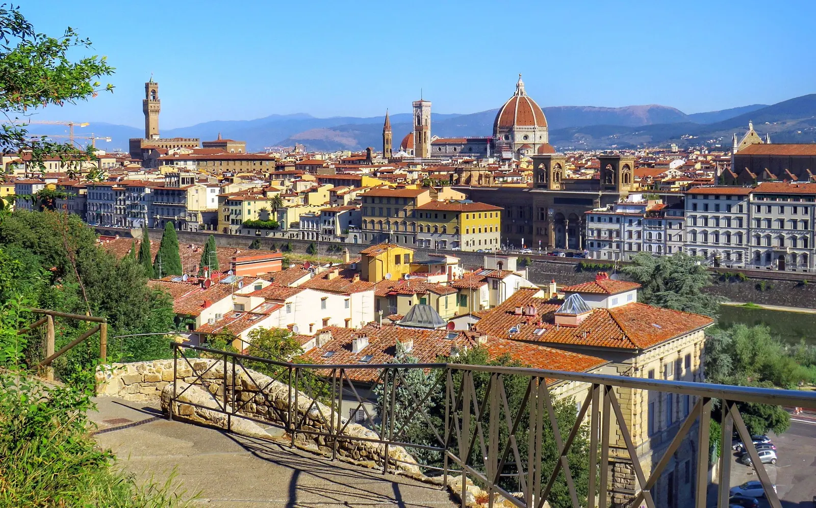 Una coppia seduta sulla scalinata di San Miniato al Monte guarda il tramonto sulla cupola del Duomo di Firenze