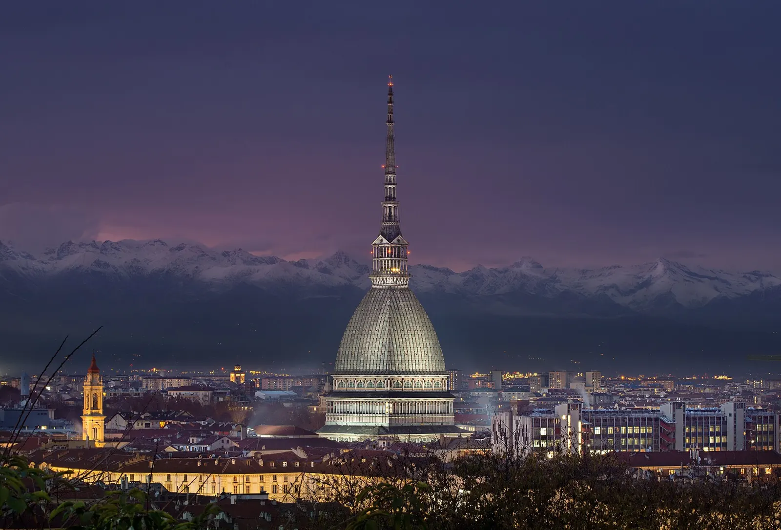 Una coppia guarda Torino e la Mole Antonelliana dal belvedere del Monte dei Cappuccini, con le Alpi sullo sfondo