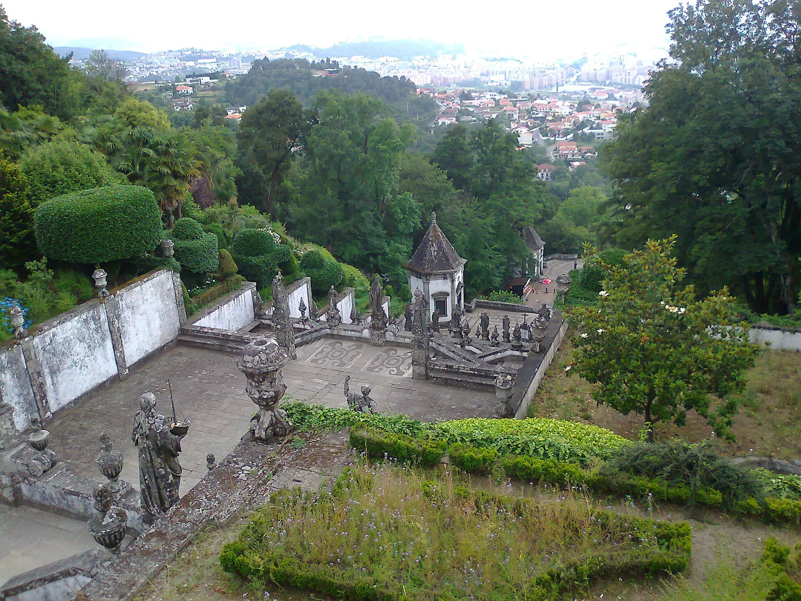 Casal a descer o escadório do Bom Jesus do Monte, em Braga, com a cidade ao fundo