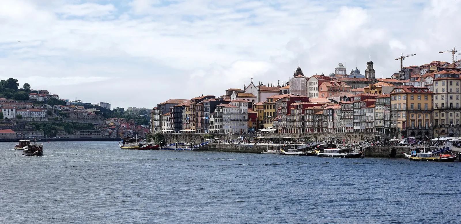 Casal no tabuleiro superior da Ponte Luís I ao pôr do sol, com a Ribeira do Porto e o Douro em baixo